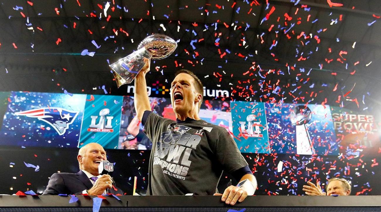 Tom Brady raises hand and holds up Vince Lombardi trophy after Super Bowl win