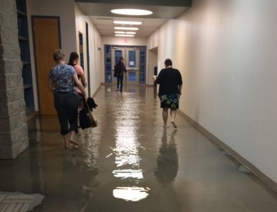 Before school began, teachers waded through the floodwater in order to get to their classrooms. 