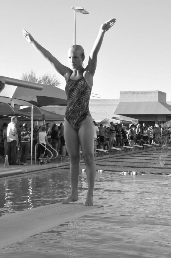 Paulina Joniec, senior, prepares for a successful dive into the water, with the support of the rest of her team.