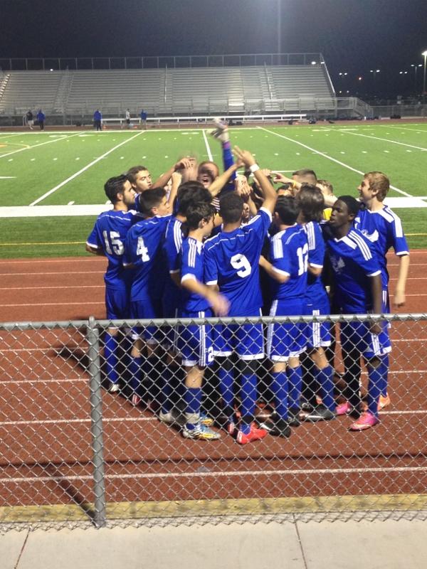 The boys soccer team celebrates their victory after the game.