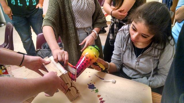 Aniah Johnson, senior, with Dena Davis, art teacher, and Diandra Baseu, freshman, are melting crayons for their 3D art project.