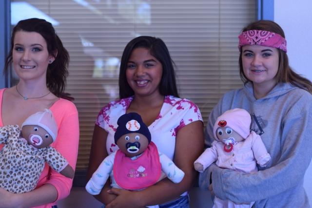 Carly McArthur, junior, Aniya Clark, freshman, Jayme Bonkoski, freshman hold their flour babies.