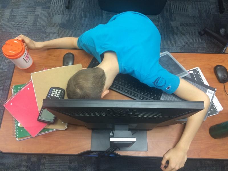 A student, staged, breaks from the mounting stress after a rush of college preparation floods in.