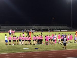 Senior powderpuff players cheer on their teammates while new players enter the game.