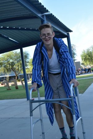 Stephan Cattermole, junior, carries a walker around campus to accompany the spirit day's reTIREDment theme.