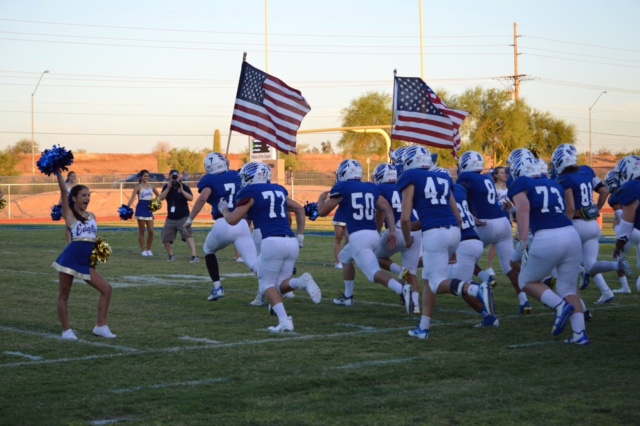 The varsity football team is greeted with this year’s cheerleaders as they run down the field.