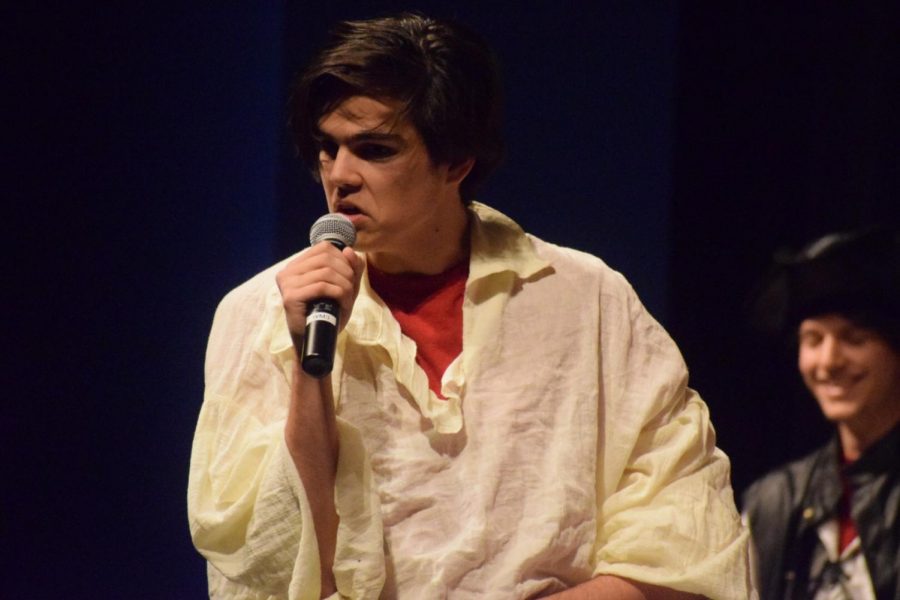 Aaron Boender, junior, sings, The Pirate Song, at the front of the stage.