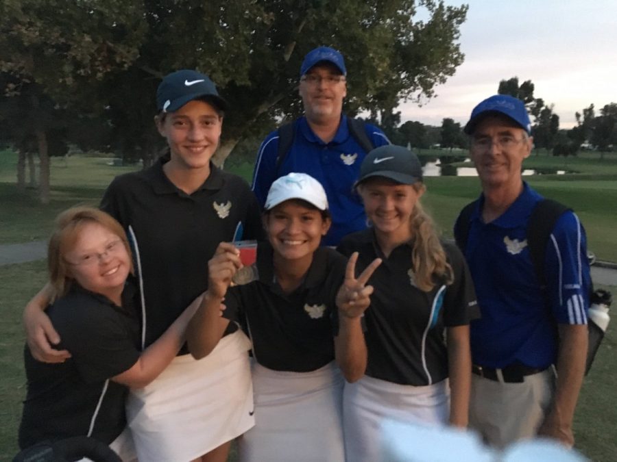 Girls golf celebrates their teammates win with coaches. 