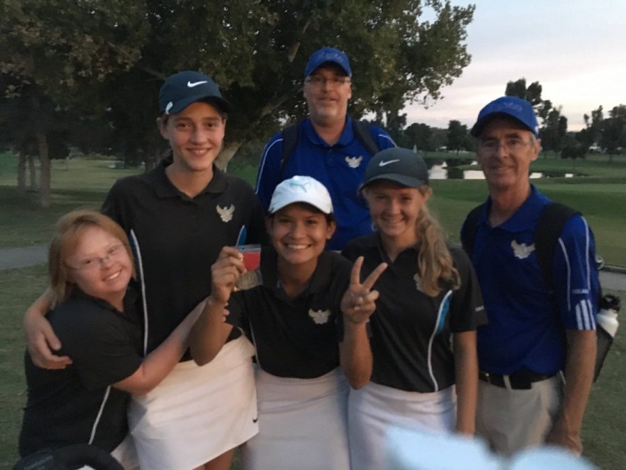 Girls+golf+celebrates+their+teammates+win+with+coaches.+