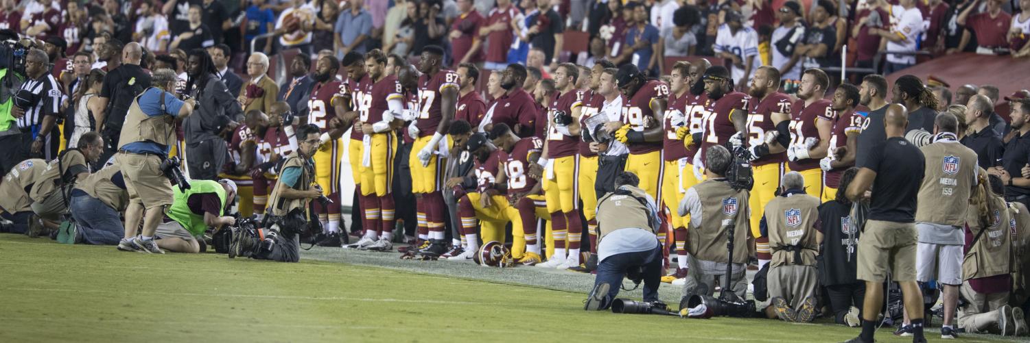 Players of the Washington Redskins NFL team neal in pprotest during the anthem