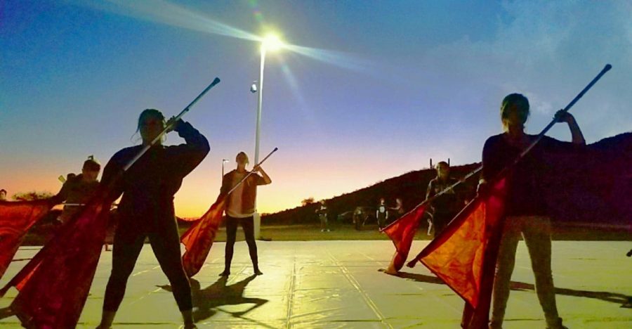 As the sun sets, winter guard keeps practicing for their new show, You Are Never Alone.