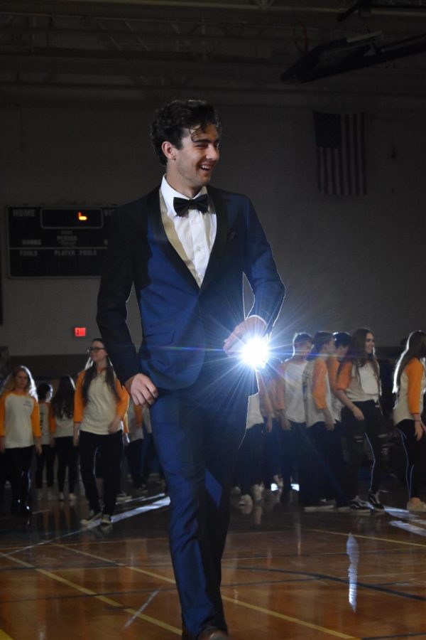 Will Harris, senior, walks across the floor at the Olympic OC Assembly 