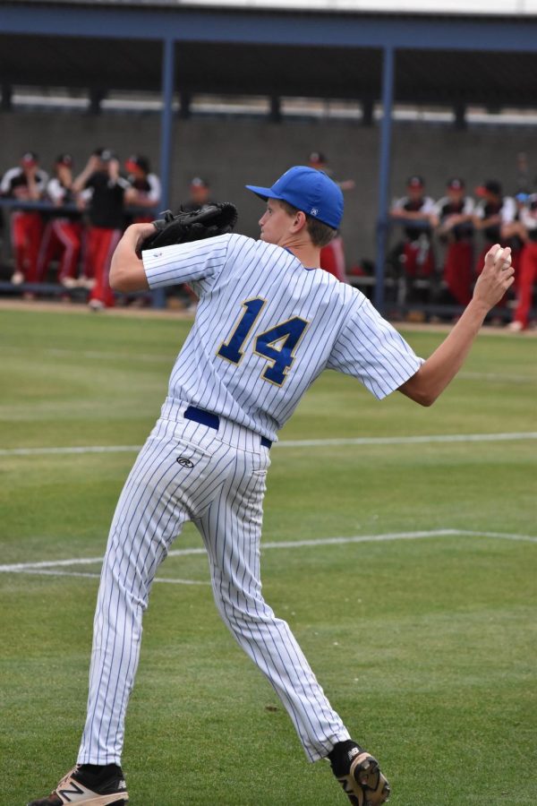 Adam Koski, sophomore, warms up his arm before  the start of another game.