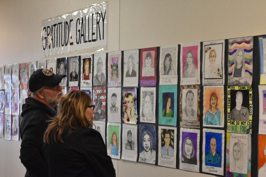 Staff members Tim Vaughn (left) and Rosa Leptich (right) stand and admire the hand drawn works of the “Gratitude Gallery.”