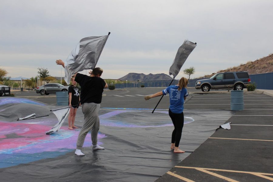 Petie Zufelt, senior (left), and Hannah Kalas, junior (right), practice a move with their flags during an afternoon rehearsal. 