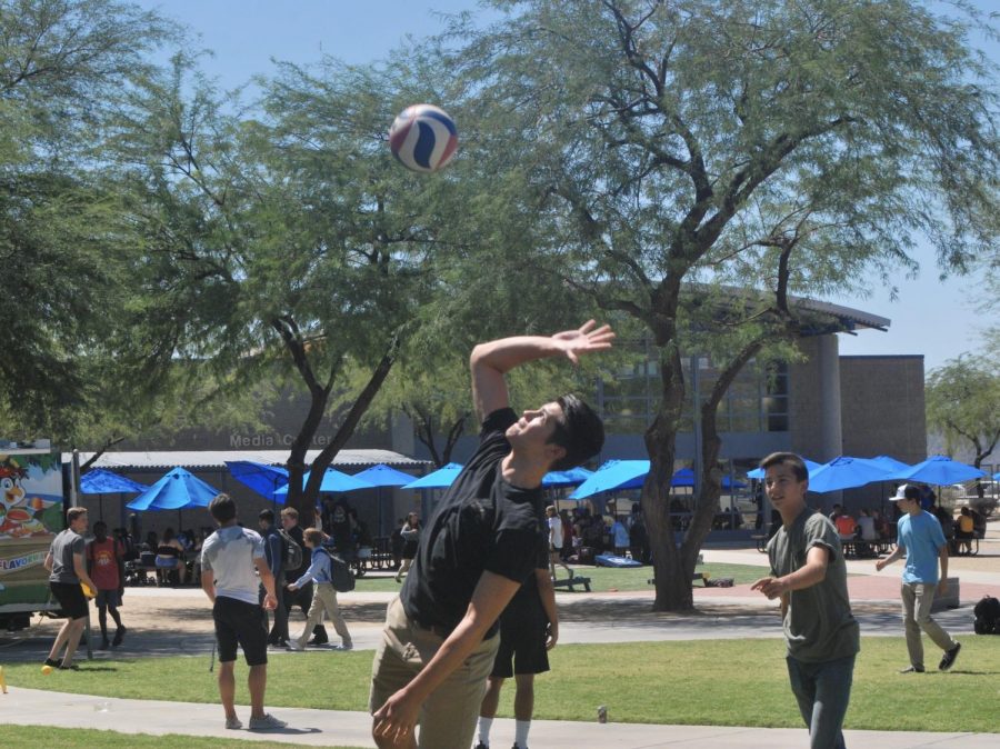 Sam Zaporowski passes Eagle Hour time by playing Volleyball near the center of campus