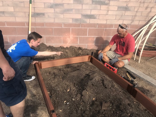 Ethan Badey (left) and Lt. Col Simmons (right) work in the ROTC garden, which is one of the many activities that ROTC participates in to support the community.