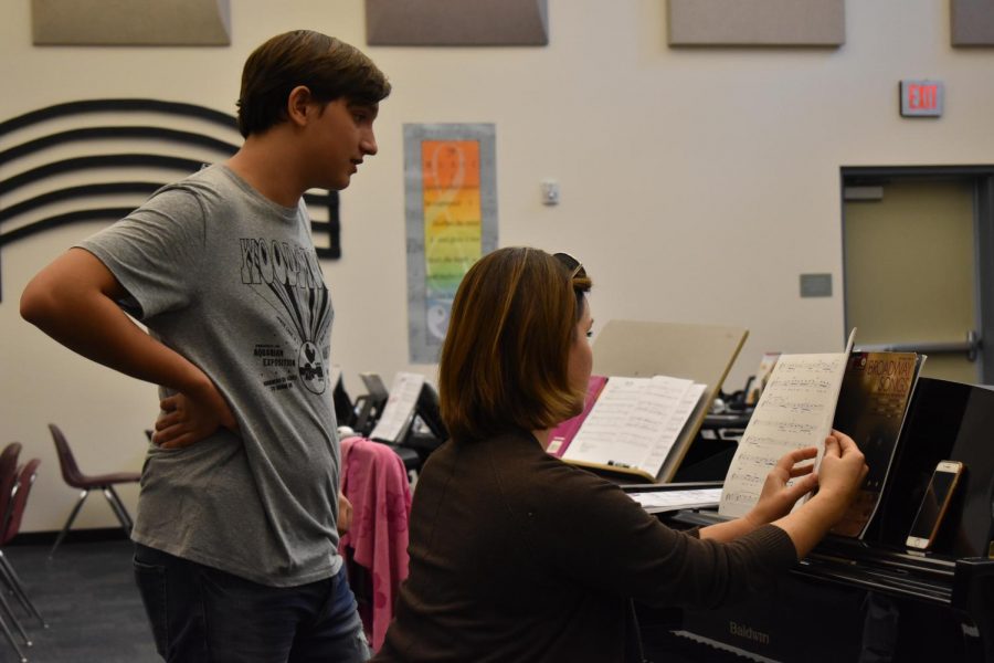Anna Backstrom, choir and piano teacher, and her student go over new music together.