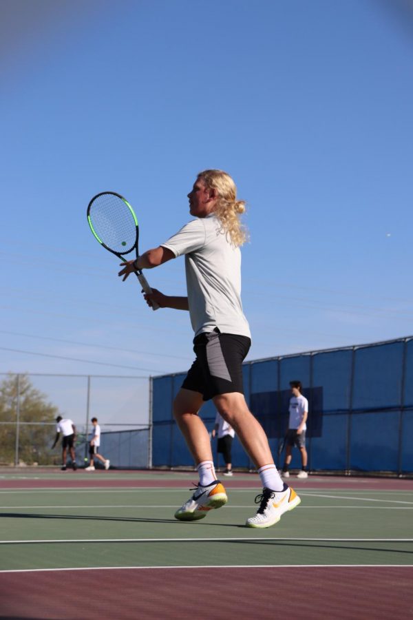 Soren Younger, senior, warms up for his match against Millennium.