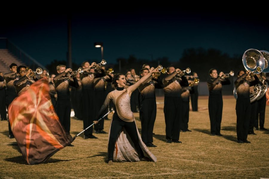 Sydeny Rost, senior, enthusiastically performs the show Wanderlust while the marching band plays behind her. 