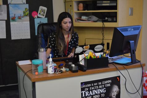 Ms. Liptow, psychology teacher, diligently prepares for class at her desk.