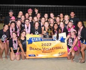 Beach volleyball smiles and poses after winning their state title.