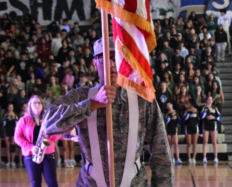 Nicholas Clark, junior, presenting the American flag at the winter assembly. 