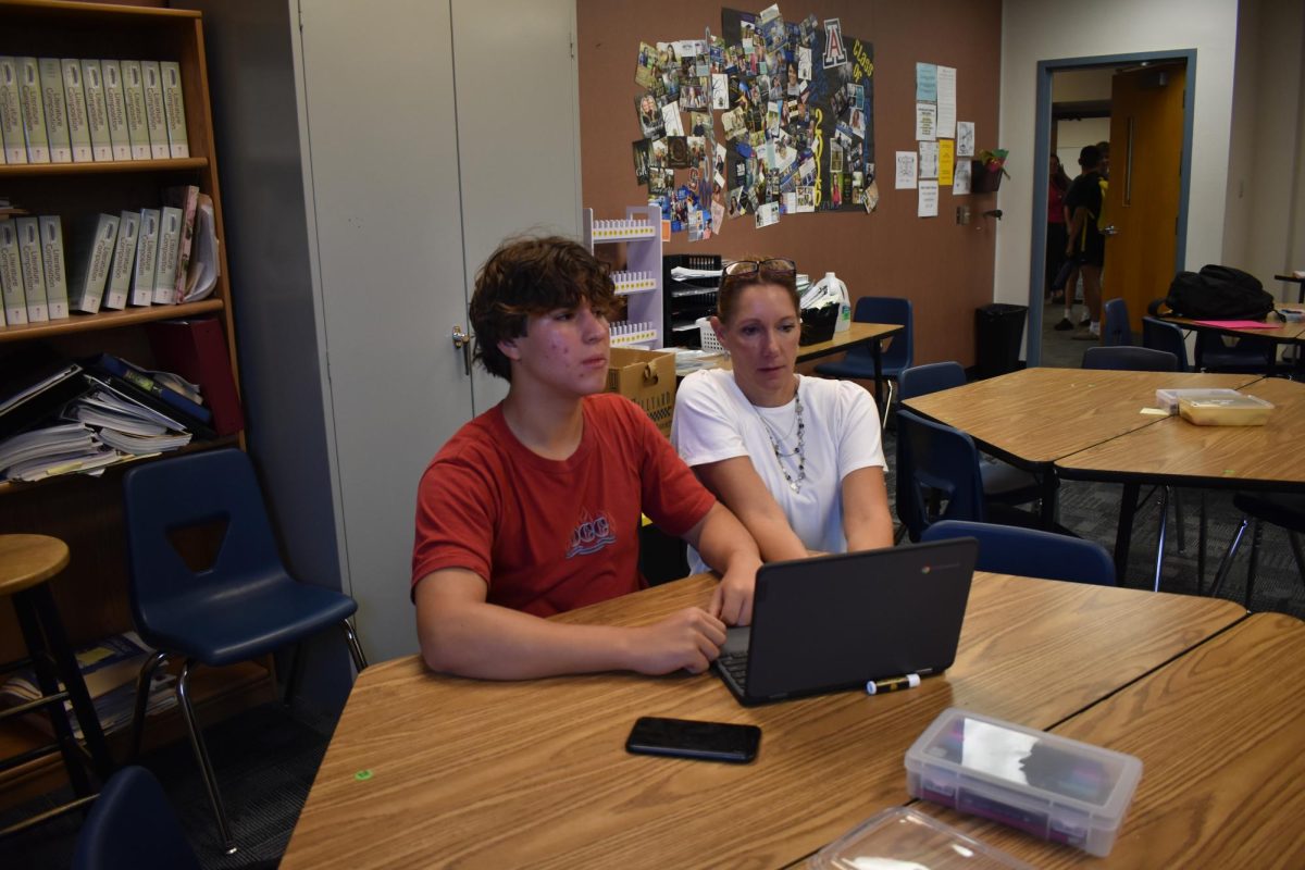 Kelly Simon, AP English Literature and Composition teacher (right), helps Kayden Popescu, junior (left), with a digital assignment.