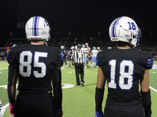 Tanner Larson, junior, right, and Christian Chung, senior, left, prepare to run into the game from the sidelines. 