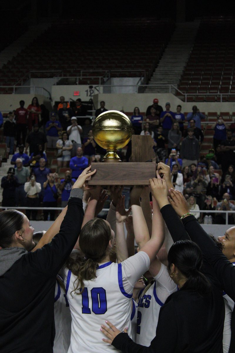 The+girls+basketball+team+hoists+the+trophy+high+after+beating+the+Perry+Pumas+to+win+the+state+championship