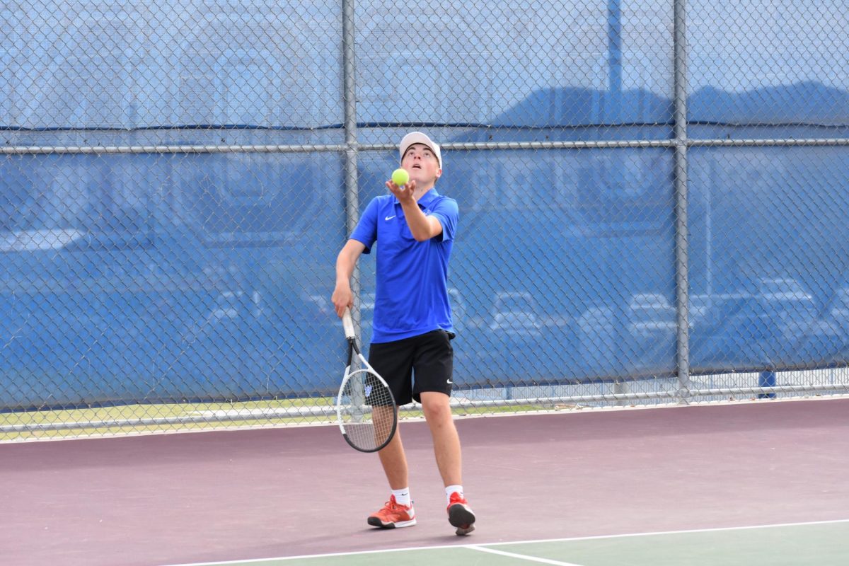 Sean Alley, senior, prepares to serve the ball while practicing for his match. 
