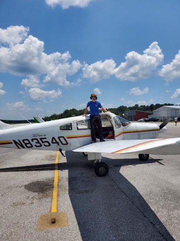 Logan Leonard, senior, stands on top of a plane at his flight school in Tuskegee, Alabama.