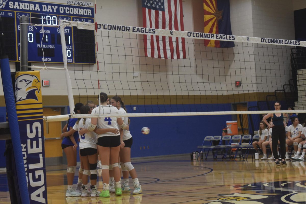 Girls volleyball team huddles to hype each other up.