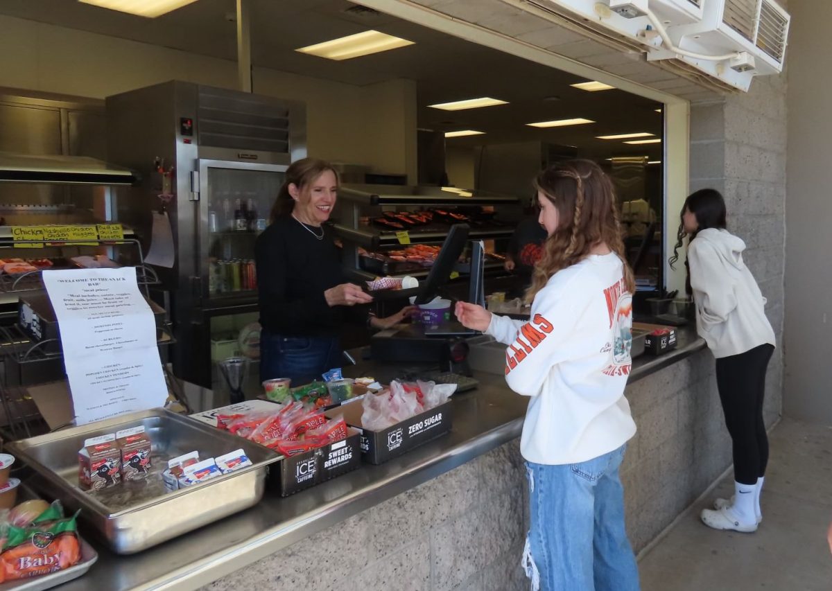 Judy Kimball, lunch lady, serves food to students.