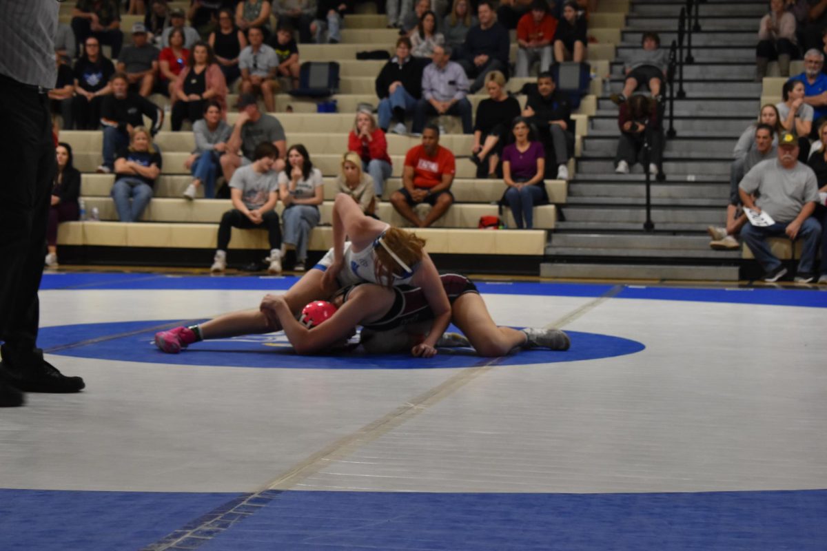 Allie Lawler, senior, wrestles her opponent to the ground.