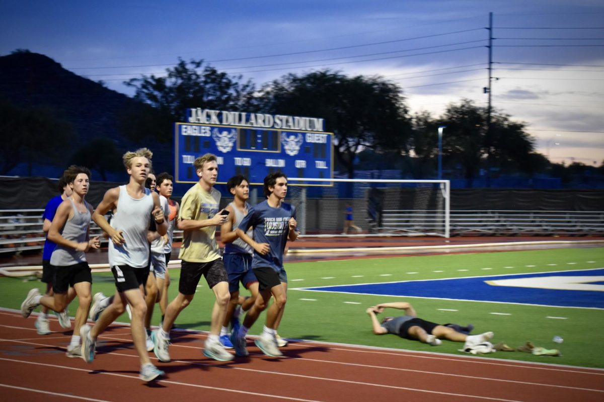 The OHS Cross Country team runs around the field for practice early in the morning.