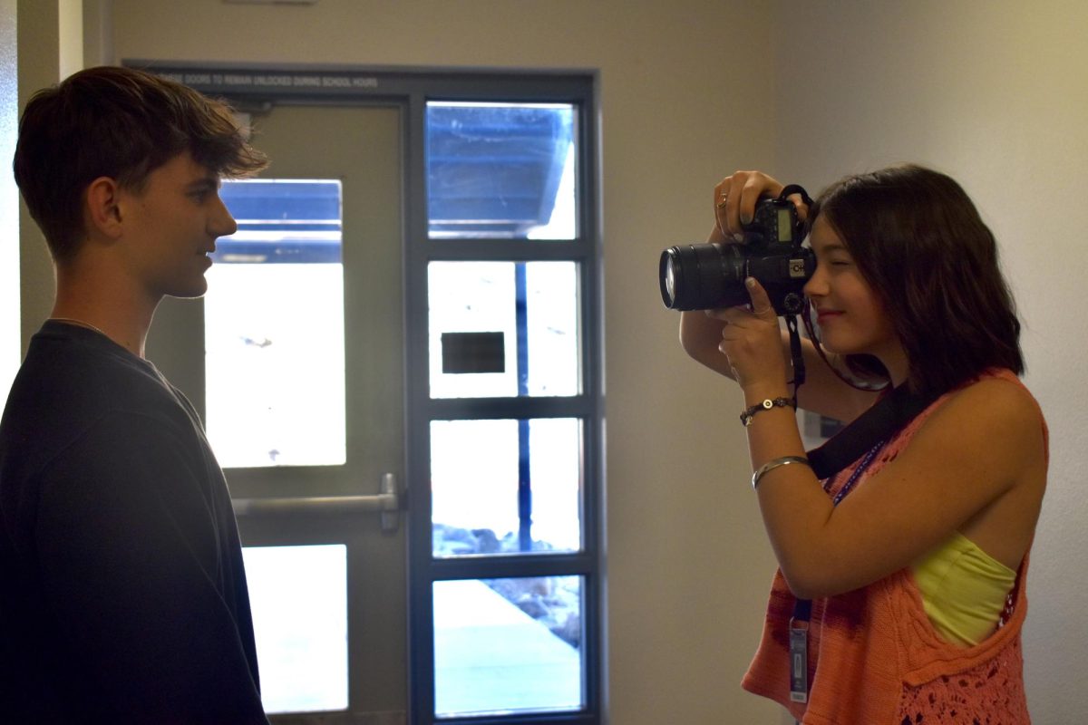 Kaia Stevensen, junior, taking a photo of Aidan Yant, junior, after an interview for Yearbook. 
