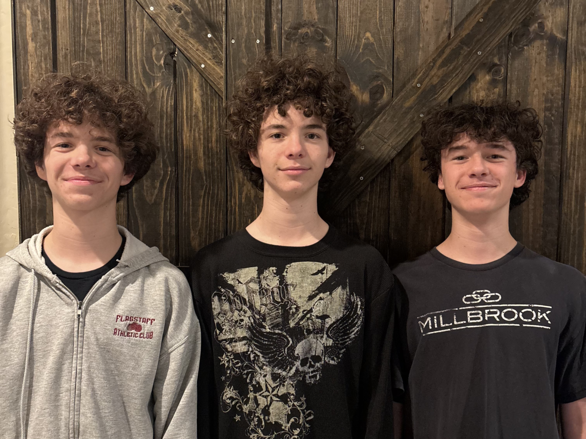 The Brennan triplets line up against a door, not only being close physically, but also in their relationship. (Left to right: Max, Andrew, and Charlie Brennan.)