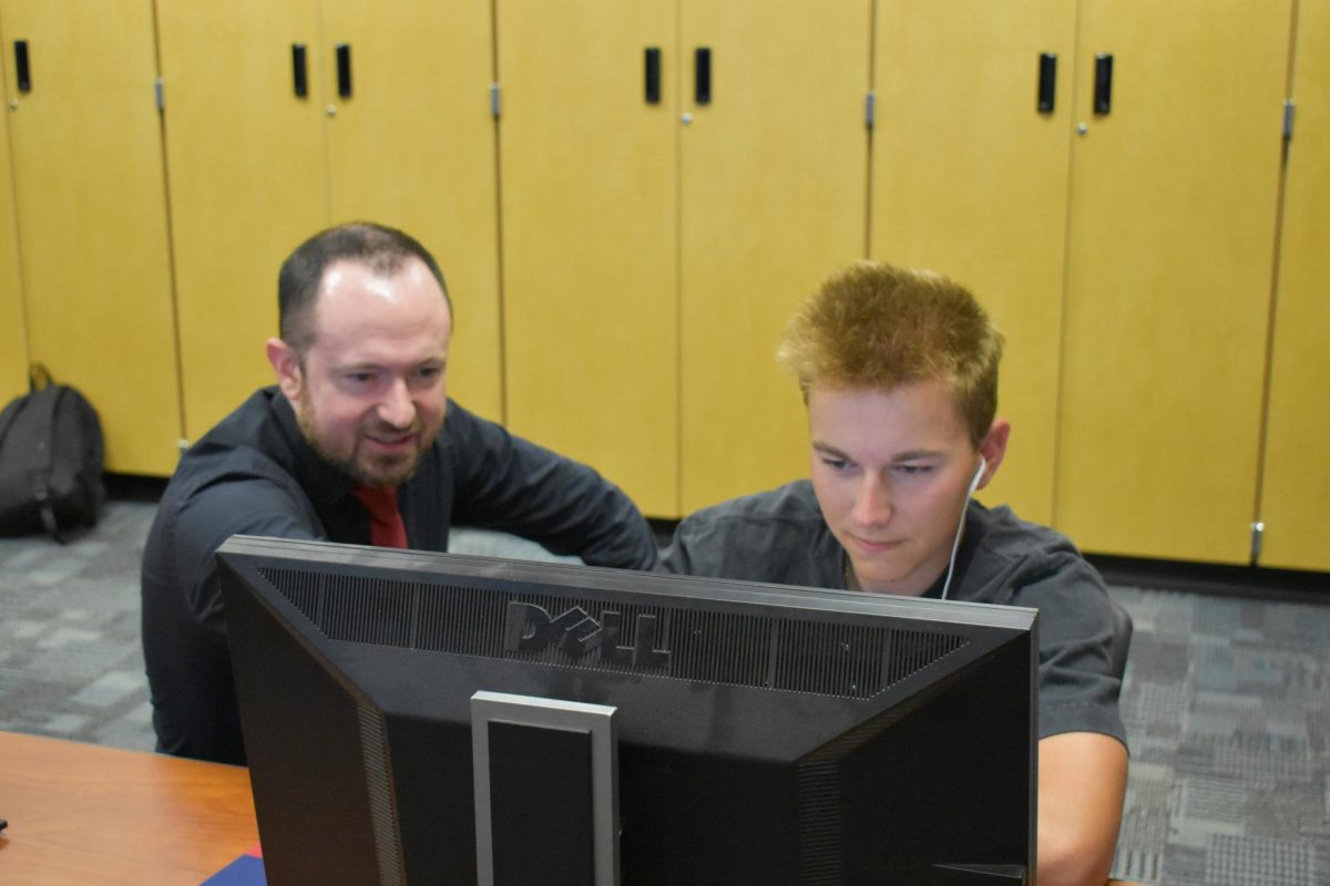 Brad Meese, film teacher, educates Cody Jones, senior, in his advanced video editing skills.