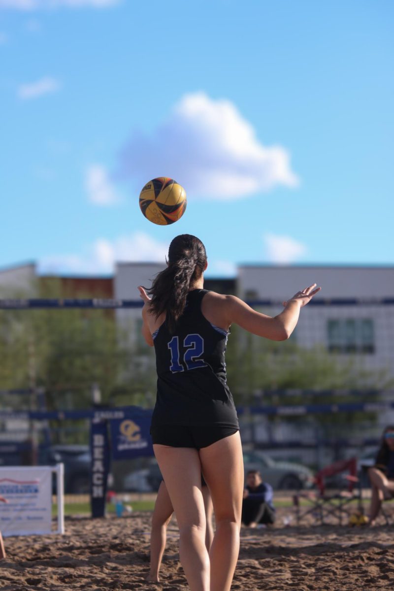 Sami Mondino, junior, serves a volleyball to the opposing team.